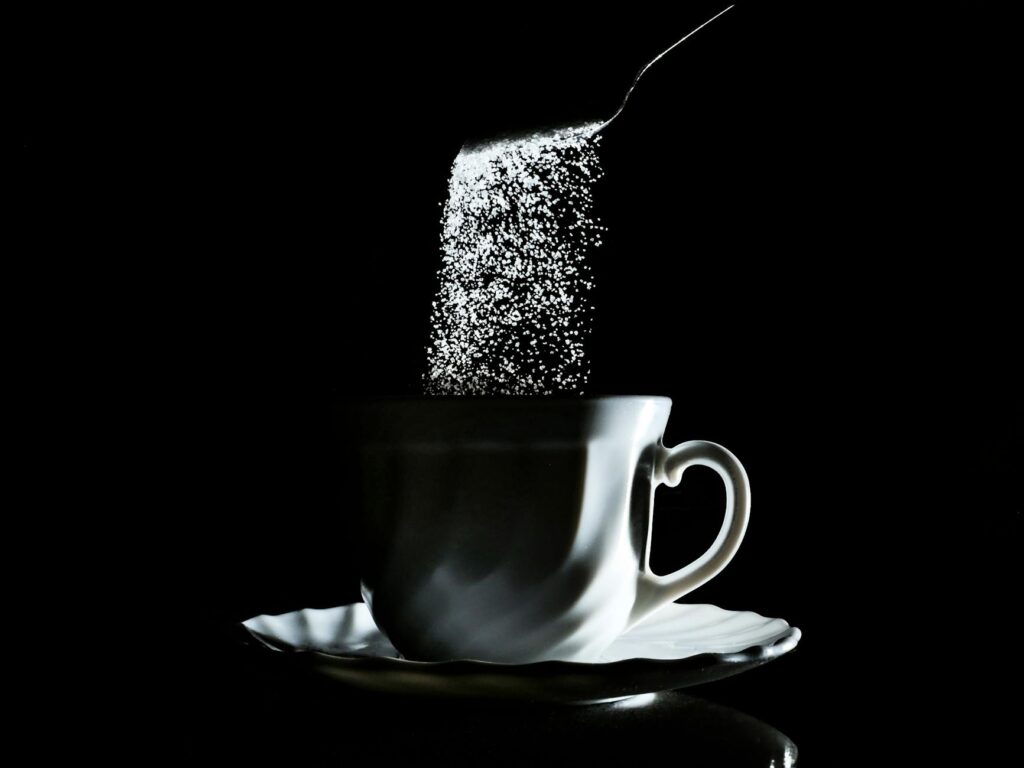 sugar falling into coffee cup