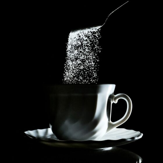 sugar falling into coffee cup
